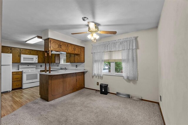 626 Sue Dr, Jackson, MO 63755 - kitchen featuring white appliances, a peninsula, brown cabinets, baseboards, and light countertops