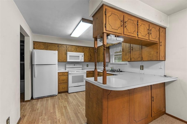 626 Sue Dr, Jackson, MO 63755 - kitchen with white appliances, brown cabinetry, a peninsula, and light countertops