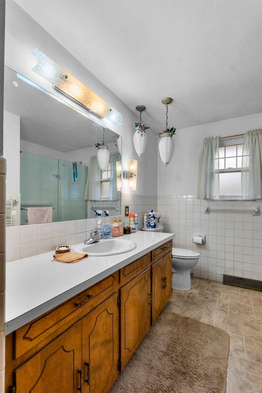 626 Sue Dr, Jackson, MO 63755 - full bath featuring tile walls, vanity, a shower with shower door, and toilet