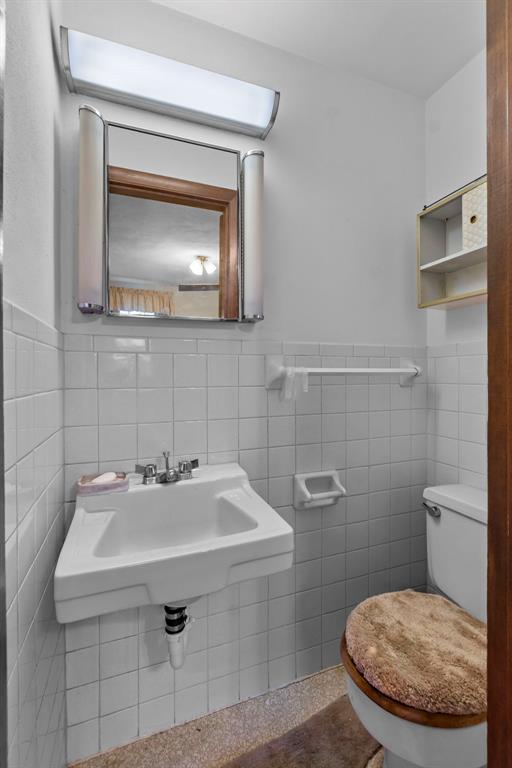 626 Sue Dr, Jackson, MO 63755 - half bathroom with tile walls, toilet, and a sink