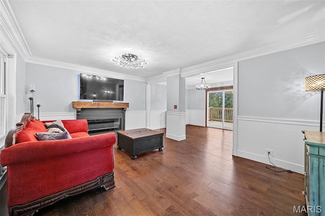 425 Cedar Ln, Wentzville, MO 63385 - living area with ornamental molding, a glass covered fireplace, wood finished floors, a textured ceiling, and a wainscoted wall