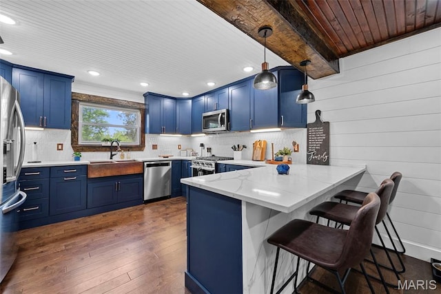 425 Cedar Ln, Wentzville, MO 63385 - kitchen with stainless steel appliances, blue cabinetry, a peninsula, recessed lighting, and wood ceiling
