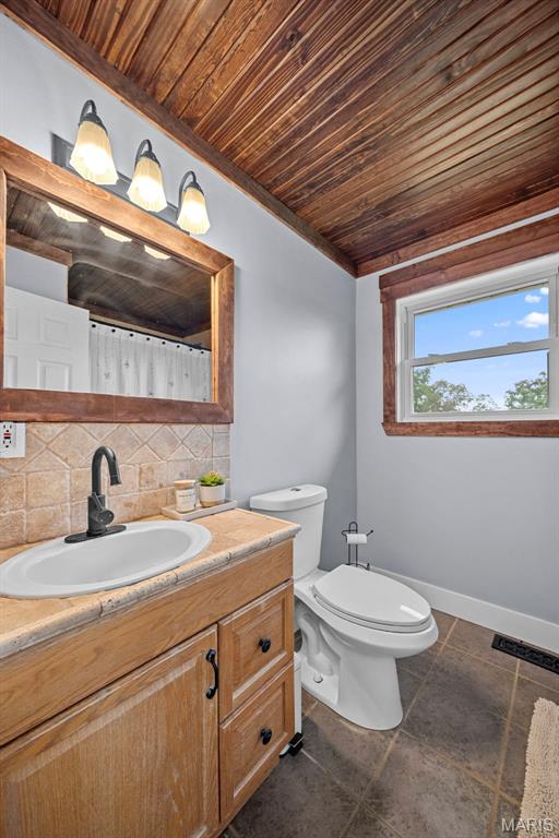 425 Cedar Ln, Wentzville, MO 63385 - full bath featuring vanity, wooden ceiling, backsplash, toilet, and baseboards