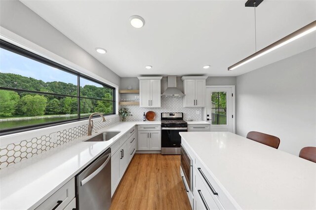 527 W Lake Dr, Edwardsville, IL 62025 - kitchen with appliances with stainless steel finishes, wall chimney exhaust hood, a sink, plenty of natural light, and recessed lighting