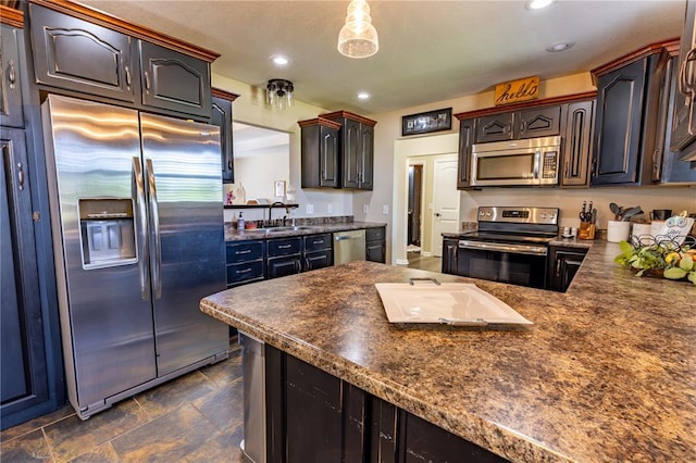 1114 Daffodil St, Sikeston, MO 63801 - kitchen with appliances with stainless steel finishes, dark countertops, a sink, recessed lighting, and dark stone finish flooring