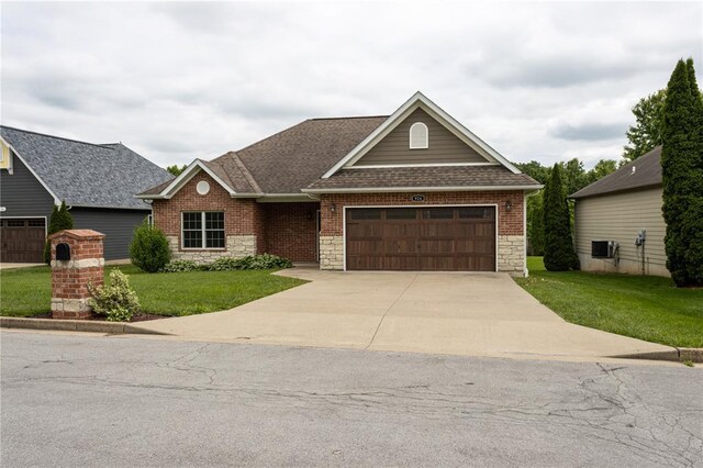 924 Brookside Ln, Rolla, MO 65401 - view of front of property with stone siding, a front yard, an attached garage, a shingled roof, and driveway