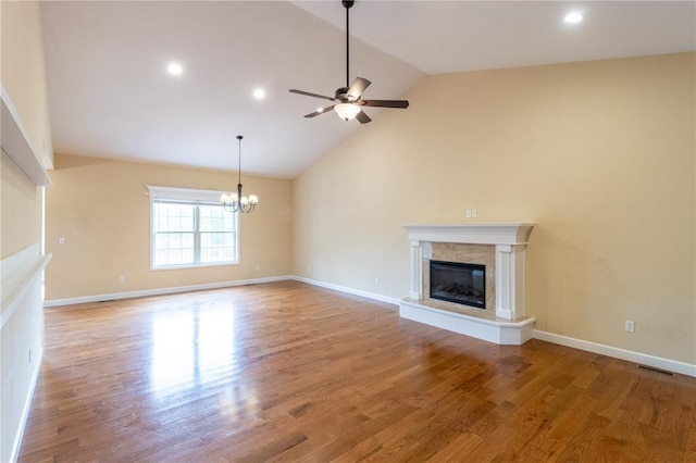 924 Brookside Ln, Rolla, MO 65401 - unfurnished living room with vaulted ceiling, ceiling fan, wood finished floors, a fireplace, and a chandelier