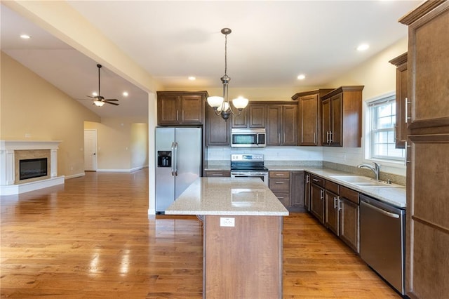 924 Brookside Ln, Rolla, MO 65401 - kitchen with appliances with stainless steel finishes, a sink, a kitchen island, decorative backsplash, and open floor plan