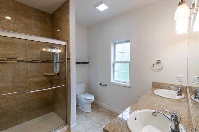 924 Brookside Ln, Rolla, MO 65401 - bathroom with toilet, a stall shower, double vanity, tile patterned floors, and baseboards