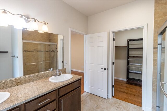 924 Brookside Ln, Rolla, MO 65401 - full bathroom with a stall shower, double vanity, tile patterned floors, and a walk in closet