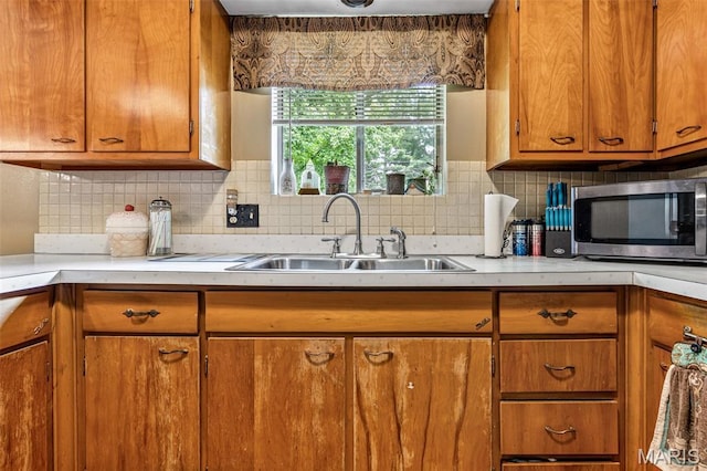 5 Heathwood Ln, Fenton, MO 63026 - kitchen with stainless steel microwave, brown cabinets, light countertops, and decorative backsplash