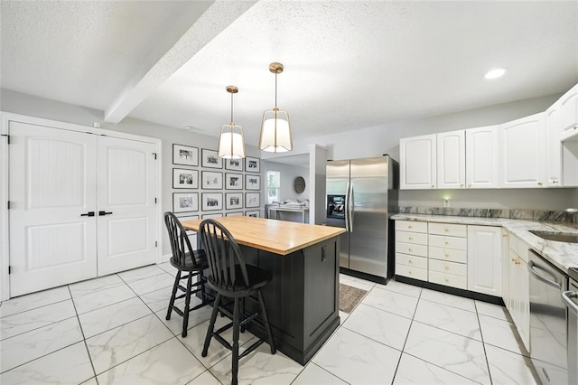 636 Parker Dr, Ballwin, MO 63021 - kitchen featuring appliances with stainless steel finishes, wood counters, light marble finish floors, white cabinets, and beam ceiling