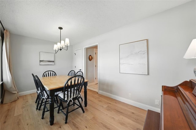 636 Parker Dr, Ballwin, MO 63021 - dining area featuring light wood finished floors, a chandelier, baseboards, and a textured ceiling