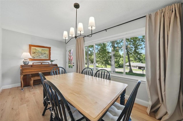 636 Parker Dr, Ballwin, MO 63021 - dining area with baseboards, light wood-style flooring, and a chandelier