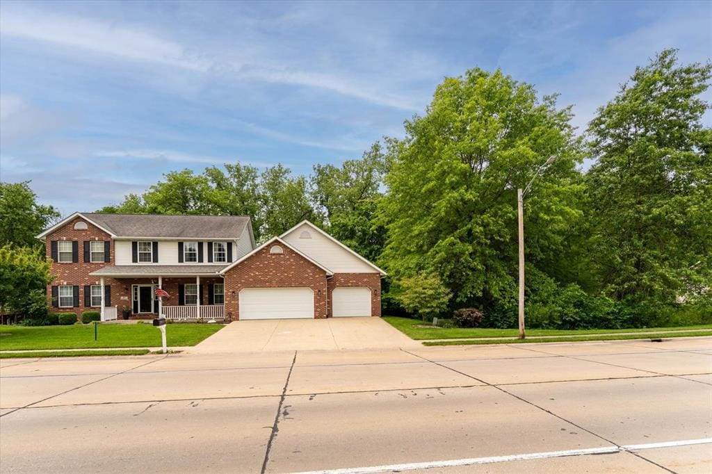 417 Fairwood Hills Rd, Ofallon, IL 62269 - colonial inspired home featuring a porch, brick siding, a front lawn, a garage, and driveway