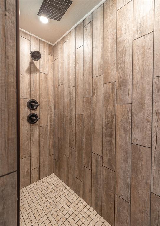 20998 Halifax Dr, Saint Robert, MO 65584 - bathroom featuring a tile shower and wood walls