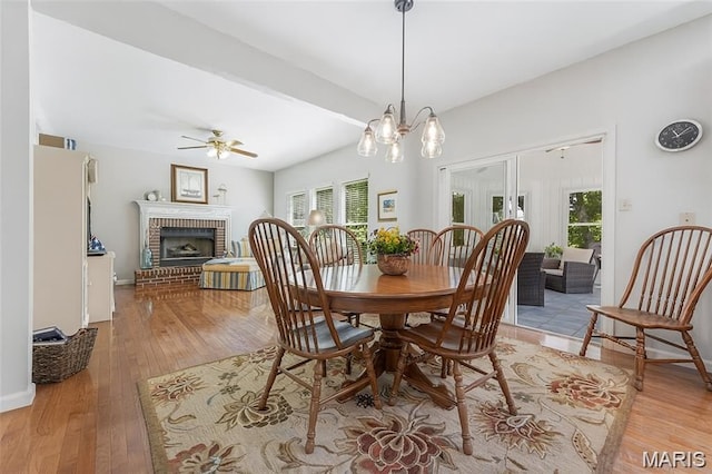 943 Sheffield Forest Ct, Saint Louis, MO 63021 - dining room featuring a brick fireplace, a ceiling fan, and light wood-type flooring