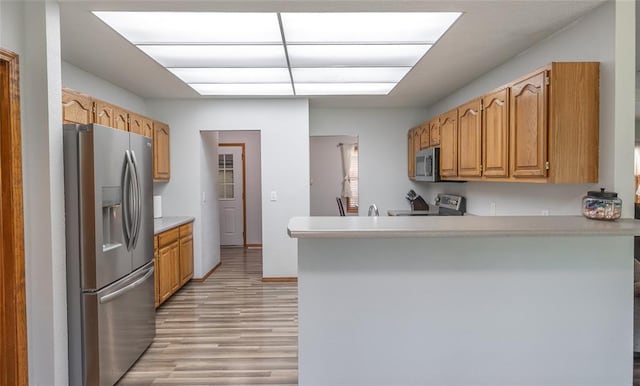 12755 Echo Ln, Plato, MO 65552 - kitchen with stainless steel appliances, light wood-style floors, light countertops, a peninsula, and a sink