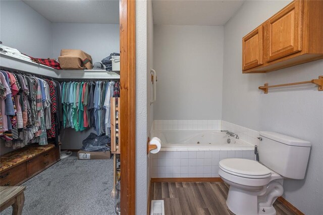 12755 Echo Ln, Plato, MO 65552 - full bath featuring a tub with jets, toilet, wood finished floors, and a walk in closet
