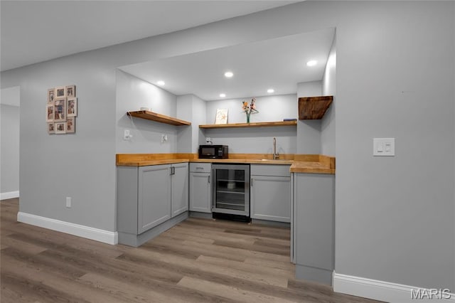 16027 Clarkson Woods Dr, Chesterfield, MO 63017 - kitchen featuring wine cooler, open shelves, gray cabinets, black microwave, and wood counters