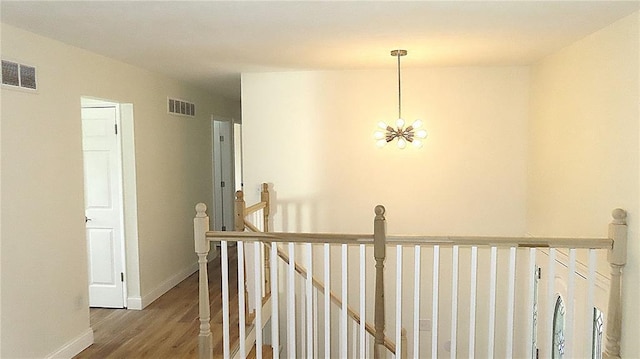 3213 Yvette Ct, Florissant, MO 63031 - hallway featuring an upstairs landing, wood finished floors, baseboards, and a chandelier