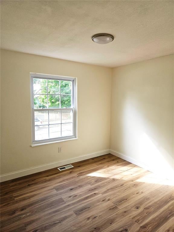 3213 Yvette Ct, Florissant, MO 63031 - empty room with wood finished floors, baseboards, and a textured ceiling