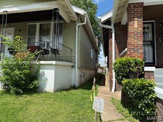 5955 Harney, Saint Louis, MO 63135 - view of home's exterior featuring covered porch, a lawn, and brick siding