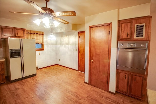 3406 Mcarthur Blvd, Alton, IL 62002 - kitchen with white fridge with ice dispenser, oven, brown cabinetry, a ceiling fan, and light wood-style flooring