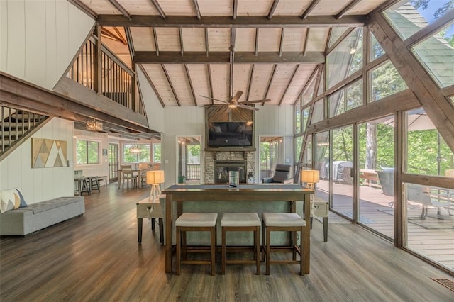 600 Innisfree Lake Dr, Innsbrook, MO 63390 - living room with high vaulted ceiling, wood finished floors, a stone fireplace, wooden walls, and ceiling fan