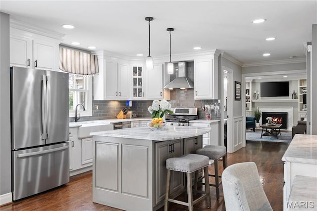 9800 Countryshire Pl, Creve Coeur, MO 63141 - kitchen with appliances with stainless steel finishes, wall chimney exhaust hood, white cabinetry, ornamental molding, and recessed lighting