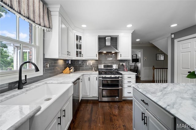 9800 Countryshire Pl, Creve Coeur, MO 63141 - kitchen with wall chimney range hood, appliances with stainless steel finishes, light stone countertops, backsplash, and glass insert cabinets