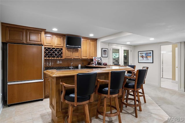 9800 Countryshire Pl, Creve Coeur, MO 63141 - indoor wet bar featuring paneled refrigerator, recessed lighting, light colored carpet, decorative backsplash, and light tile patterned floors