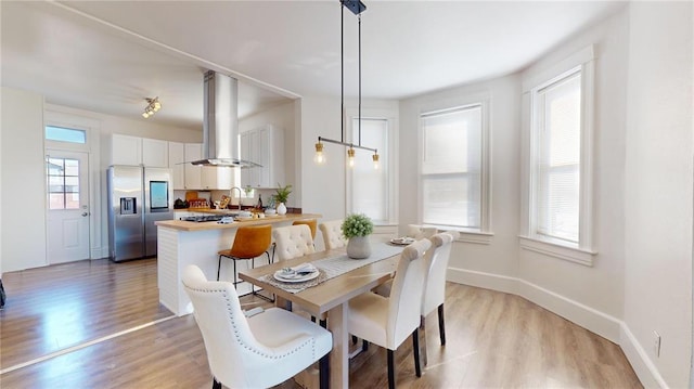 dining room with light wood-style flooring and baseboards