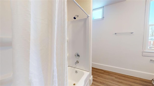 full bath with wood finished floors, shower / bath combo with shower curtain, and baseboards