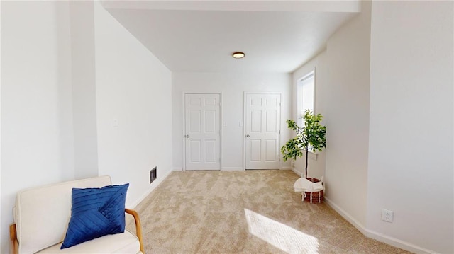 sitting room featuring carpet floors and baseboards