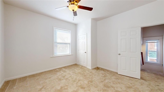 unfurnished bedroom featuring multiple windows, carpet, a closet, and baseboards