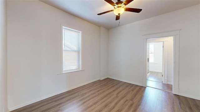 empty room with wood finished floors, ceiling fan, and baseboards