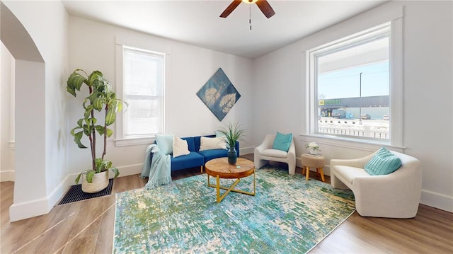 sitting room featuring wood finished floors, ceiling fan, and baseboards