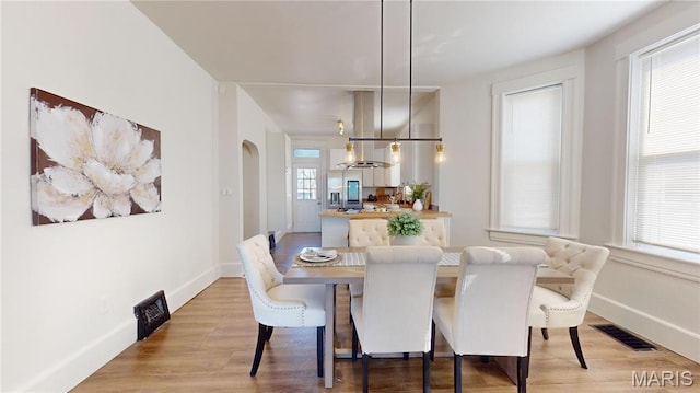 2111 W Main St, Belleville, IL 62226 - dining area with light wood-type flooring, baseboards, and arched walkways