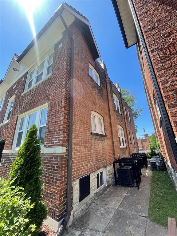 2715 Arkansas Ave, Saint Louis, MO 63118 - view of side of home featuring brick siding, a patio area, and central AC