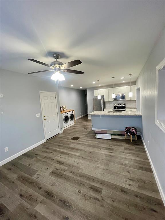 2715 Arkansas Ave, Saint Louis, MO 63118 - kitchen featuring appliances with stainless steel finishes, white cabinets, separate washer and dryer, dark wood-type flooring, and a ceiling fan