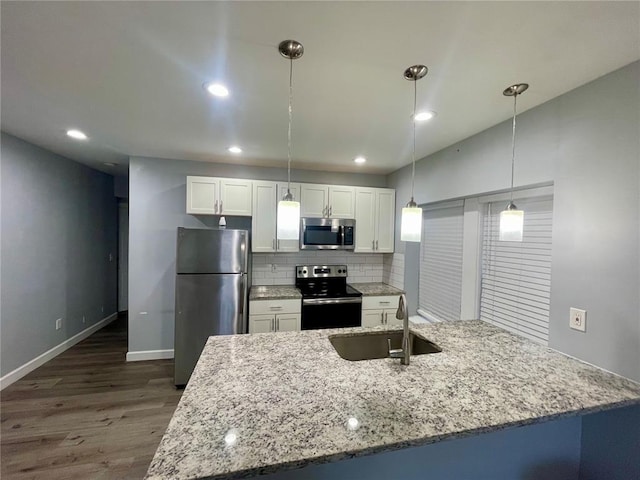 2715 Arkansas Ave, Saint Louis, MO 63118 - kitchen featuring appliances with stainless steel finishes, a sink, dark wood finished floors, white cabinets, and light stone counters