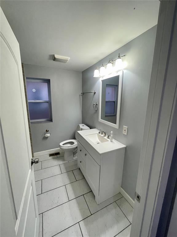 2715 Arkansas Ave, Saint Louis, MO 63118 - bathroom featuring baseboards, toilet, and vanity