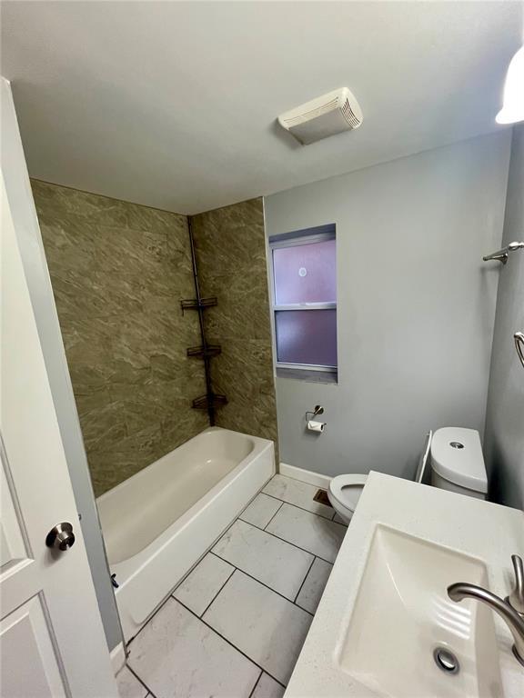 2715 Arkansas Ave, Saint Louis, MO 63118 - full bathroom featuring a sink, toilet, marble finish flooring, bathing tub / shower combination, and baseboards
