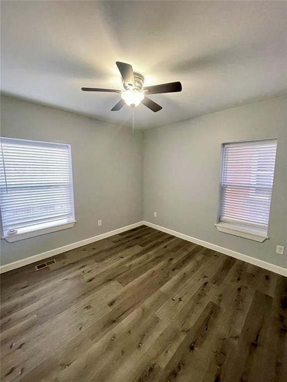 2715 Arkansas Ave, Saint Louis, MO 63118 - empty room with plenty of natural light, a ceiling fan, baseboards, and dark wood finished floors