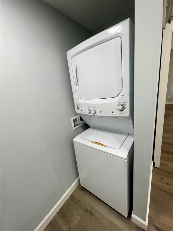 2715 Arkansas Ave, Saint Louis, MO 63118 - laundry area featuring stacked washer / drying machine, wood finished floors, and baseboards