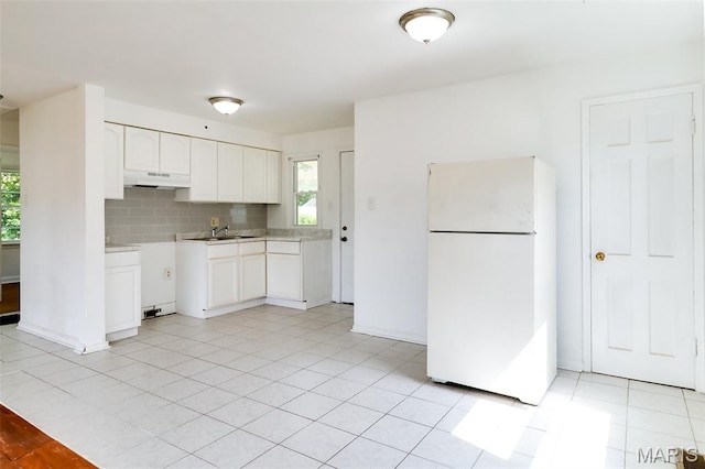8115 Myrick St, Berkeley, MO 63134 - kitchen featuring freestanding refrigerator, under cabinet range hood, healthy amount of natural light, and white cabinets