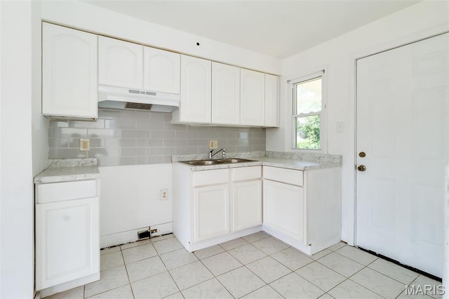 8115 Myrick St, Berkeley, MO 63134 - kitchen featuring under cabinet range hood, a sink, decorative backsplash, and white cabinets