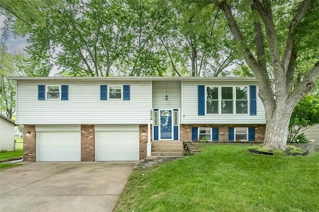 raised ranch featuring brick siding, driveway, a front yard, and an attached garage