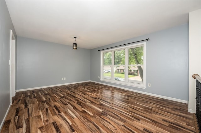 unfurnished room with dark wood-style floors and baseboards